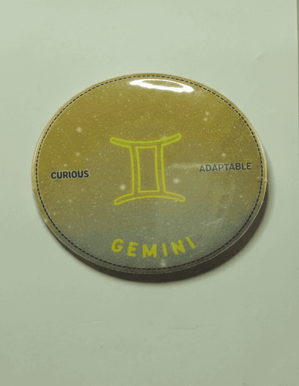 Gemini zodiac badge with yellow symbol and starry background