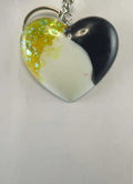 Heart-shaped keychain with black and white marble, iridescent yellow flakes, and a silver chain