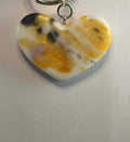 Heart-shaped resin keychain with gold, black, and white swirls and glitter accents