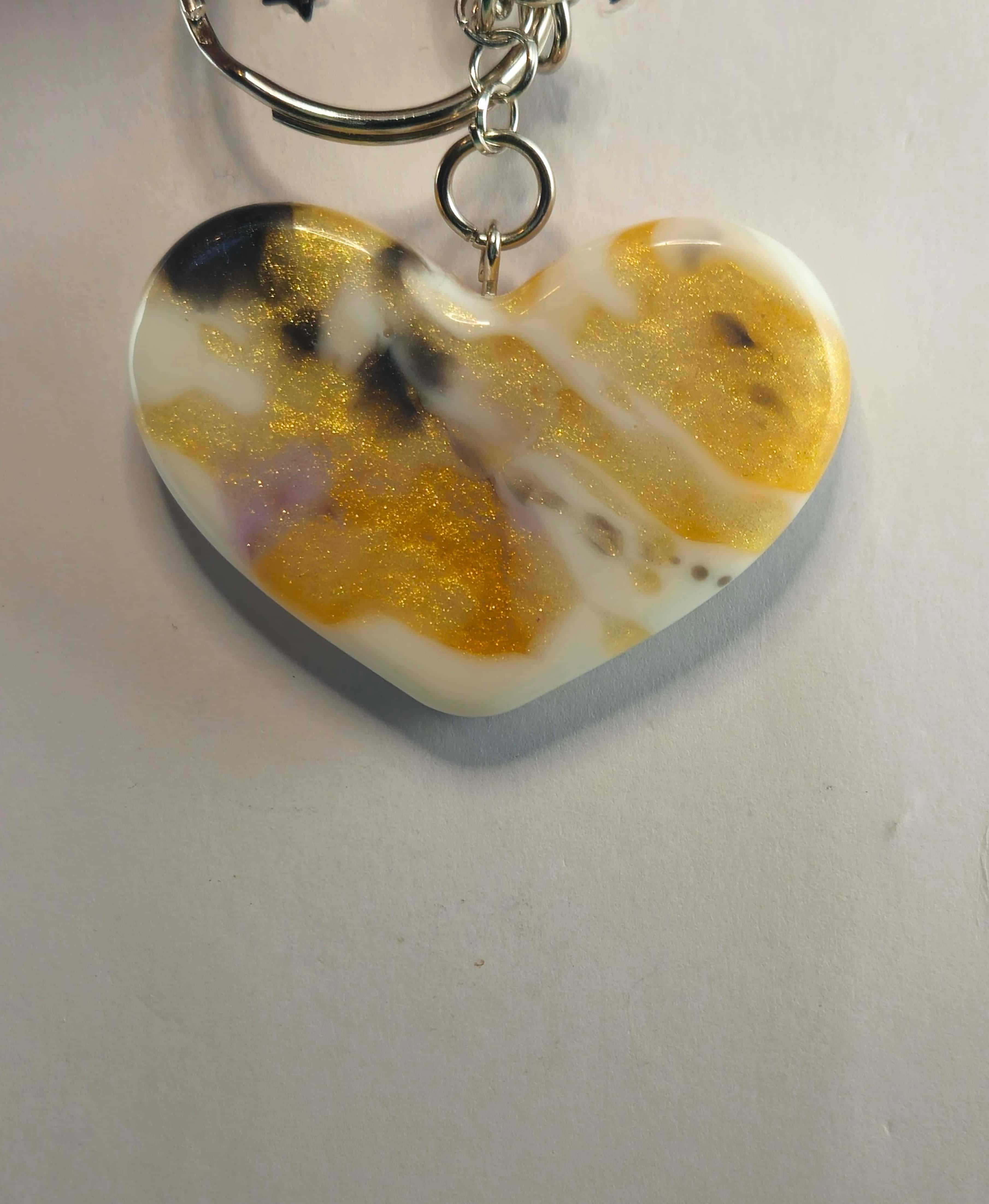 Heart-shaped gold and white resin keychain with glitter accents