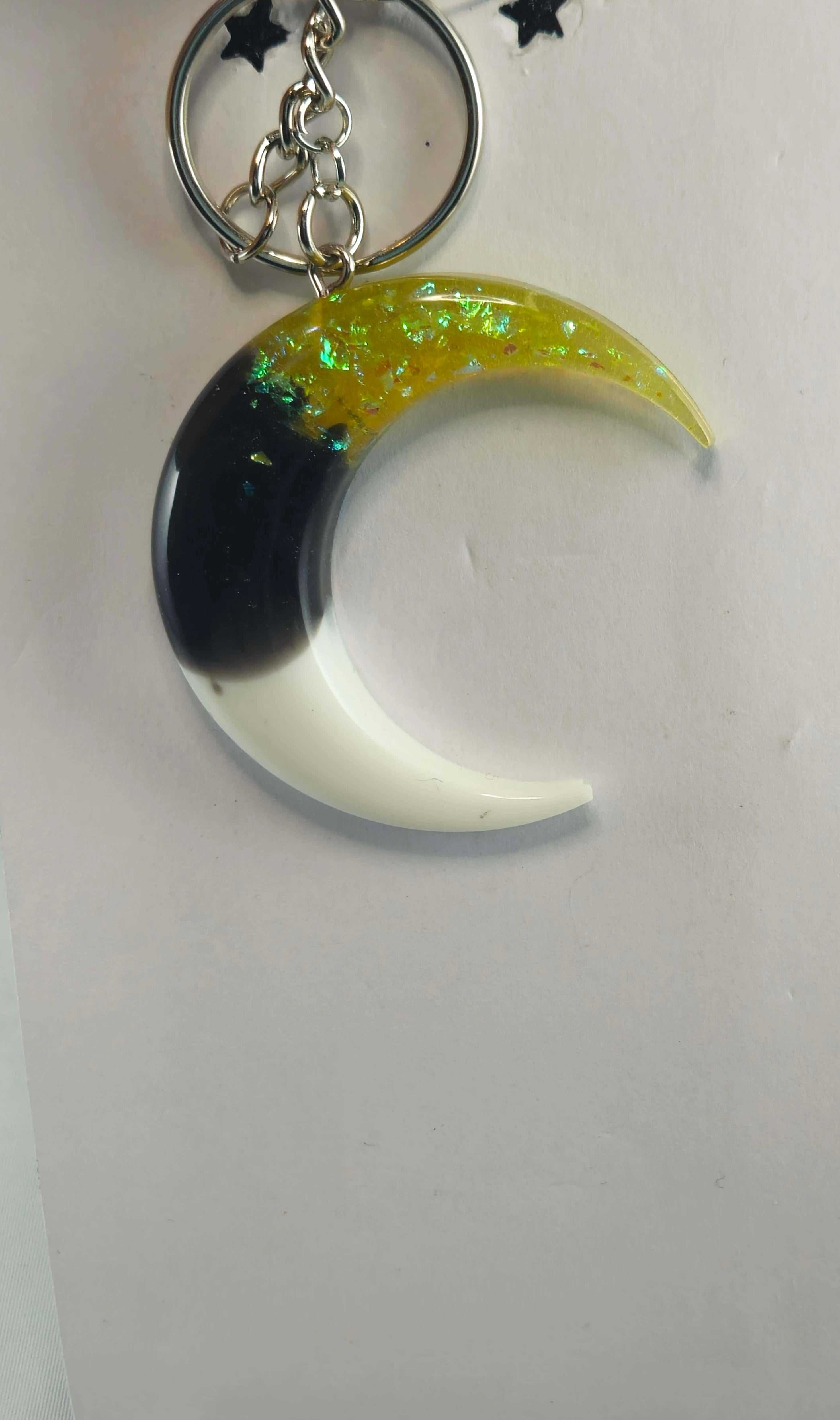 Yellow, black, and white crescent moon keychain with iridescent flakes
