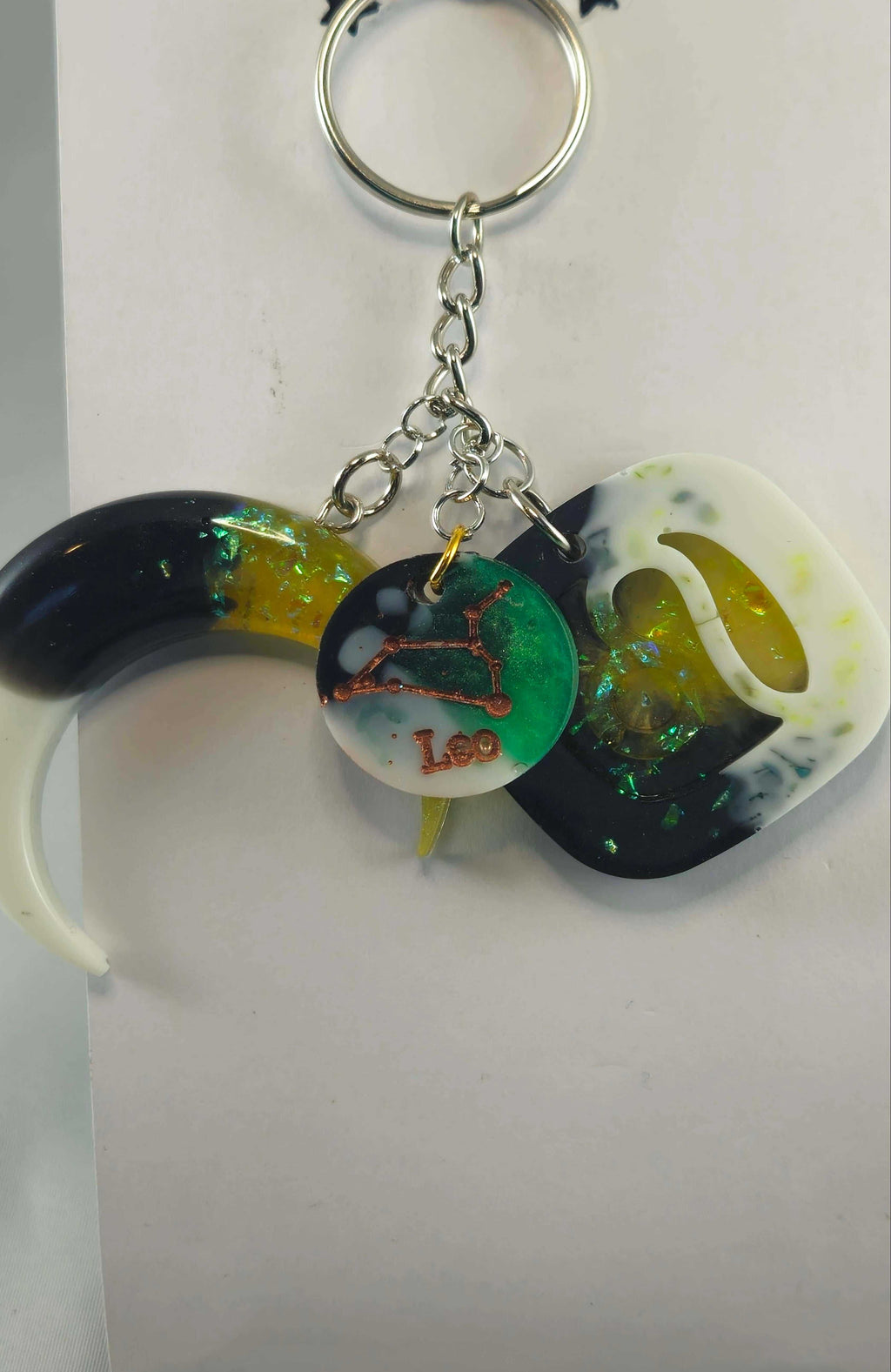 Miner's Galore Leo zodiac charm keychain with white, black, and iridescent green resin elements