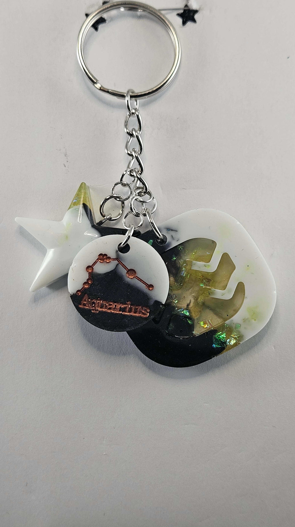 White, yellow, and black Aquarius zodiac keychain with design