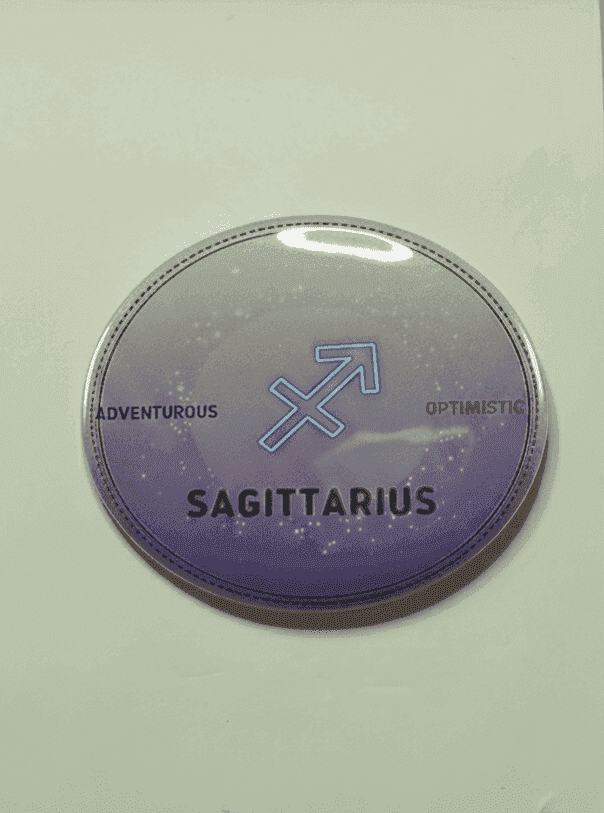 Sagittarius zodiac badge with silver and purple ombre design, adventurous and optimistic traits